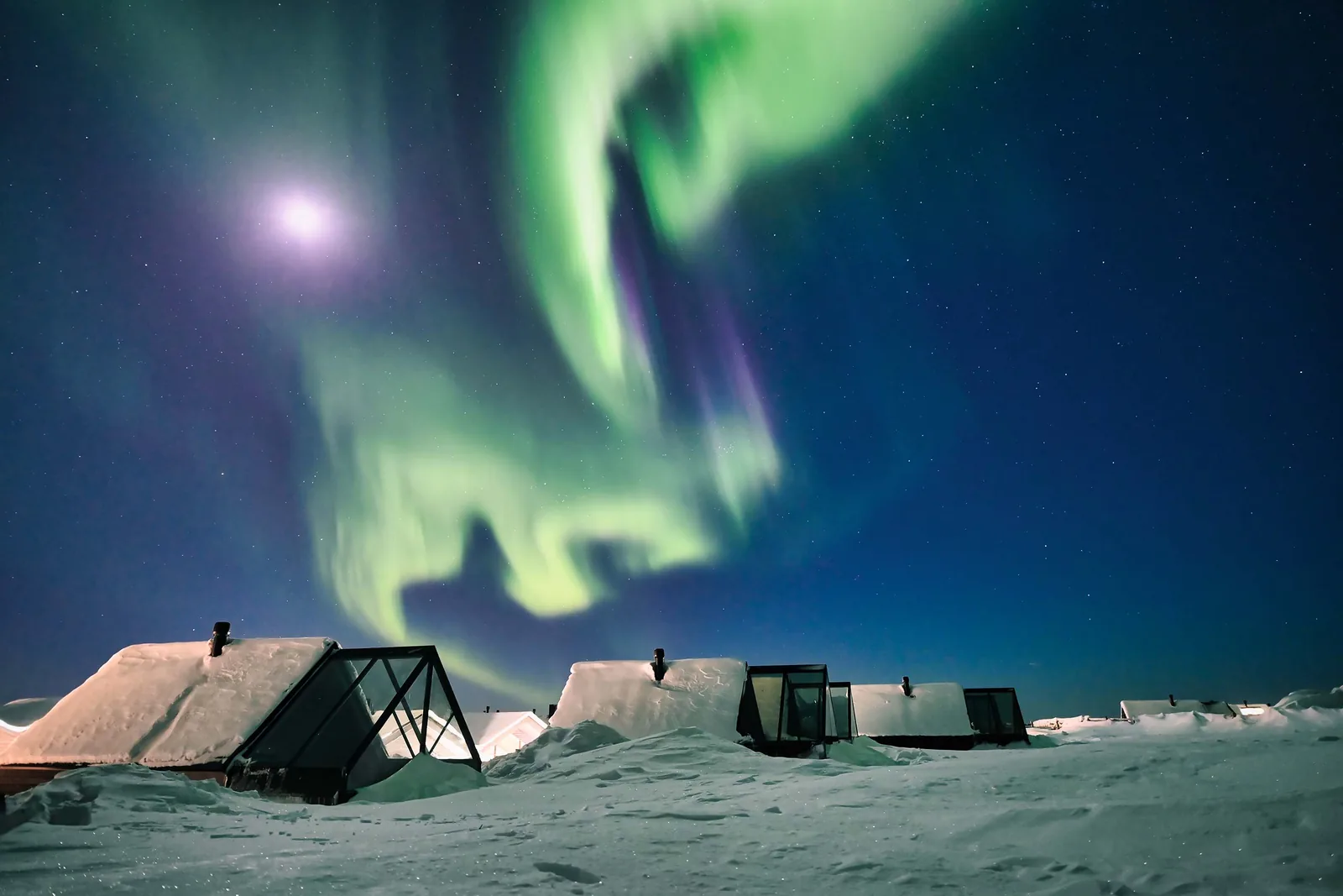 Glass-roofed cabins beneath the northern lights in Finnish Lapland